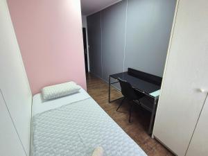 ein kleines Zimmer mit einem Bett und einem Schreibtisch in der Unterkunft Hostel M in Maribor + 18 Fotos