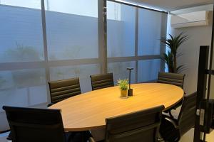 una sala conferenze con tavolo e sedie in legno di Flat pé na areia Alta Garden - MyFlats Hospedagens a João Pessoa Altre 34 foto