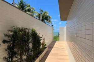 un corridoio di un edificio con piante sul lato di Flat pé na areia Alta Garden - MyFlats Hospedagens a João Pessoa