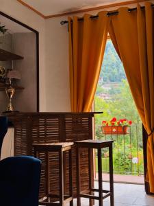 une pièce avec une table, des chaises et une fenêtre dans l'établissement Sunrise Inn & Campo da Tennis, à Mezzenile