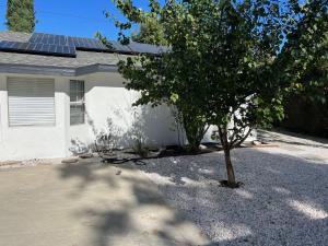 a house with a tree in a gravel driveway at Brand new private one bed one bath home with private parking for 2 in Van Nuys Airport