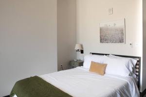 ミルウォーキーにあるDeer District Studio Apt - One Block from Fiserv & Bairdの白いベッドと白い枕のある寝室