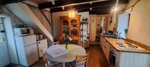 a kitchen with a table with a vase of flowers on it at Derriana Cottage in Waterville