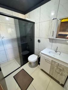 a bathroom with a shower and a toilet and a sink at Pousada Container Guarda do Embaú in Palhoça +8 photos