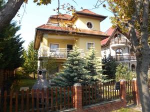 a house behind a fence with a christmas tree at Apartment in Zamardi - Balaton 33875 in Zamárdi