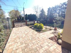 a brick walkway with a wooden fence in a yard at Apartment in Zamardi - Balaton 33875 in Zamárdi +10 photos