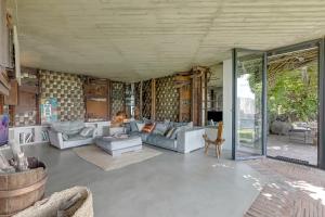 ein Wohnzimmer mit Sofas, Tischen und Glastüren in der Unterkunft Villa Skyline - Pool - Lakeview - Privacy - Happy Rentals in Lugano