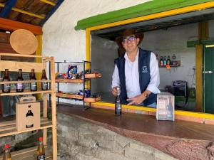 a man standing behind a counter with a bottle of wine at Cabaña Dos Búhos in Murillo