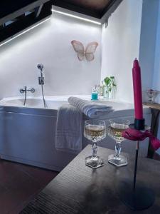 a bathroom with a bath tub and two glasses of wine at Civitella Relais in Civitella dʼAgliano