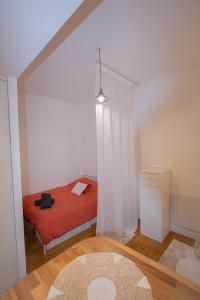 a bedroom with a bed with a red comforter at L'Escapade Choletaise in Cholet