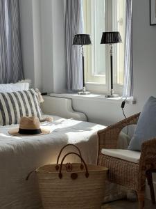a bedroom with a bed and a chair and two windows at SeeBlick Apt 7 Bałtyk Luxury Residence in Międzyzdroje