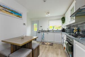 a kitchen with white cabinets and a wooden table at Comfortable & cozy Home Stay in East Kilbride +6 photos