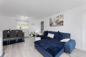 a living room with a blue couch and a table at Comfortable & cozy Home Stay in East Kilbride