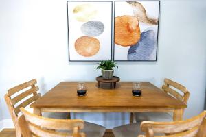 a dining room table with two glasses and a plant on it at Jennifer's Elegant & Cozy Broadway Retreat in Providence
