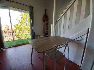 a table and chair in a room with a window at Appartement T2 Duplex 50m2, Marseillan Etang Thau, clim, terrasse in Marseillan