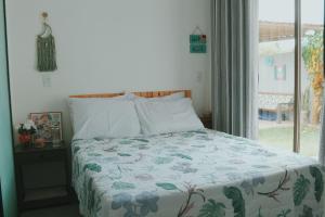 un letto in una camera da letto con finestra di Casa em Ipioca | piscina, área gourmet, Hibiscus Beach Club a Ipioca Altre 17 foto