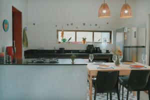 una cucina con un tavolo con sedie e un piano di lavoro di Casa em Ipioca | piscina, área gourmet, Hibiscus Beach Club a Ipioca