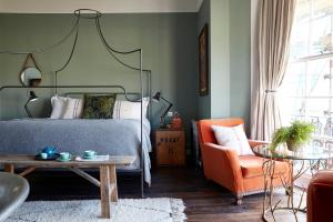 a bedroom with a bed and a chair and a table at Artist Residence Brighton in Brighton & Hove