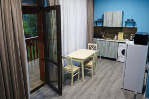 a kitchen with a table and chairs and a refrigerator at Calm Home Apartment in Mestia