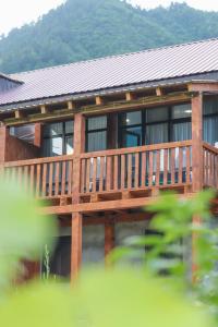 a wooden deck on a house with mountains in the background at Calm Home Apartment in Mestia