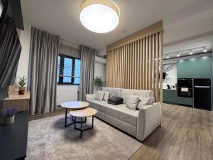 una sala de estar con un sofá y una mesa en AFI Apartments, en Suceava