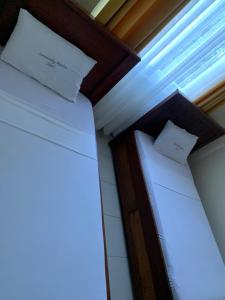 Dos camas en una habitación con sábanas y almohadas blancas. en Summer luxury apartments, en Mombasa
