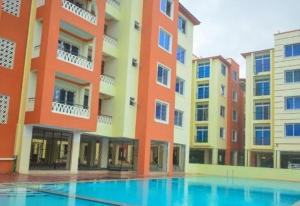 a large building with a swimming pool in front of it at Summer luxury apartments in Mombasa