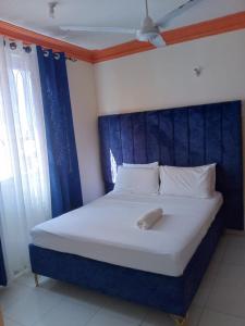 1 cama grande con cabecero azul en una habitación en Summer luxury apartments, en Mombasa