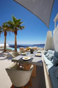 Ein Tisch und Stühle auf einer Terrasse mit Blick auf das Meer in der Unterkunft Villa Aura in Firostefani