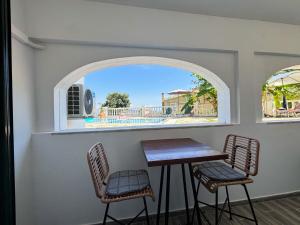 a table and two chairs in a room with a window at Kalami Bay Apartment in Kalami