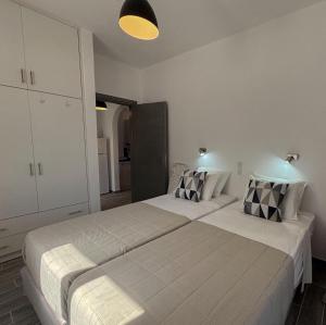 Dos camas en una habitación con paredes blancas. en Kalami Bay Apartment, en Kalámi