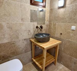 a bathroom with a bowl sink on a wooden table at Pasithea Luxury Studio in Mikrós Prínos