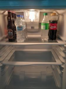 una nevera abierta con botellas de soda y agua en OB Apt 8, en Christ Church 17 fotos más