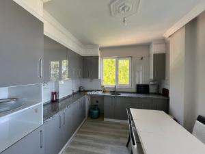 a kitchen with white cabinets and a table and a window at Semiha hanım konağı in Perşembe