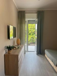 a bedroom with a bed and a dresser and sliding glass doors at Maison Aielli 112 in San Giuseppe Vesuviano