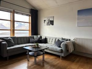 a living room with a couch and a table at Koselig rekkehus i Longyearbyen in Longyearbyen