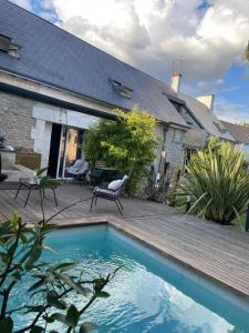 Un patio trasero con piscina y una casa. en Villa événements Balnéo & Spa, en Villampuy