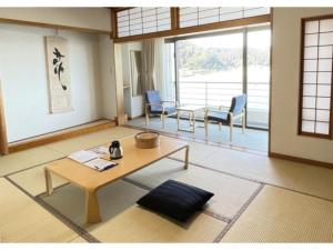 a living room with a table and chairs in it at Hotel Aoshima Cinqmale - Vacation STAY 67409v in Miyazaki