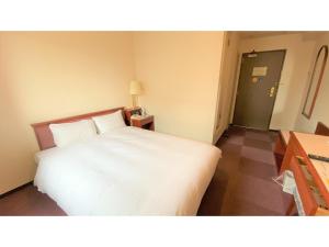 a bedroom with a white bed in a room at Smile Hotel Kitaasaka - Vacation STAY 69671v in Asaka
