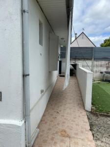 a white building with a door and a walkway at Maisonnette aéroport Orly in Paray-Vieille-Poste