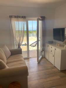 a living room with a couch and a sliding glass door at Your Home @ Benagil in Lagoa