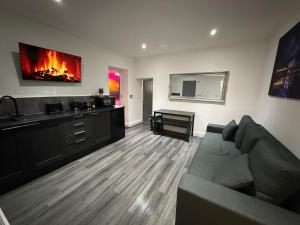 Una sala de estar con un sofá y una chimenea. en Hornby Hottub and Jacuzzi Suites, en Blackpool