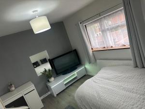 a bedroom with a bed and a flat screen tv at Comfortable Room Near Stacey's Corner Basildon in Basildon