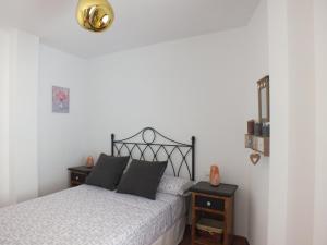 a bedroom with a bed with two nightstands and a gold light at Casa Walt in Mojácar