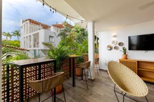 a balcony with a table and chairs and a tv at Raices Nomadas Boutique Hotel Vallarta in Puerto Vallarta