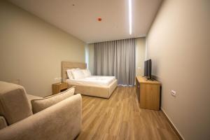a hotel room with a bed and a television at Pegasus-In Hotel Borsh in Borsh +16 photos