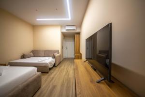 a living room with a couch and a flat screen tv at Pegasus-In Hotel Borsh in Borsh