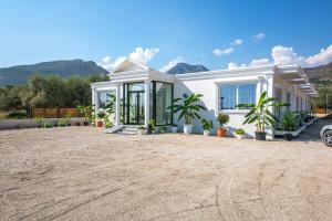 a white house with mountains in the background at Pegasus-In Hotel Borsh in Borsh