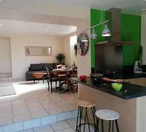 Cossé-le-VivienにあるGite La ferme aux vachesのテーブルと椅子のあるキッチンとリビングルーム