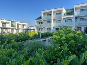 a garden in front of an apartment building at Apartament Sunset Resort Grzybowo in Grzybowo